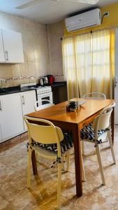 a kitchen with a wooden table and two chairs at Departamento Baba in Clorinda