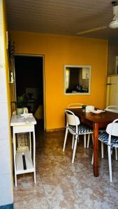 a table and chairs in a room with a yellow wall at Departamento Baba in Clorinda