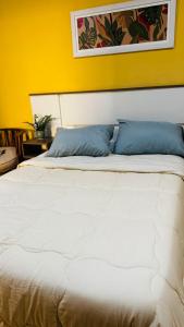 a white bed with blue pillows in a room at Departamento Baba in Clorinda