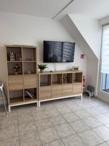 ein Wohnzimmer mit einem Flachbildfernseher auf einem Entertainment-Center in der Unterkunft Fewo Hammelblick in Xanten