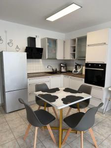 eine Küche mit Tisch und Stühlen und einem Kühlschrank in der Unterkunft Fewo Hammelblick in Xanten