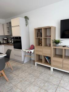 eine Küche mit weißen Schränken und einem TV an der Wand in der Unterkunft Fewo Hammelblick in Xanten + 4 Fotos