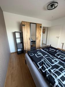 ein Schlafzimmer mit einem Bett mit einer schwarzen Bettdecke in der Unterkunft Fewo Hammelblick in Xanten