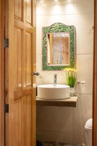 ein Badezimmer mit Waschbecken und Spiegel an der Wand in der Unterkunft San José del Pacífico- Cabañas Camino al Cielo 3 in San Jose del Pacifico
