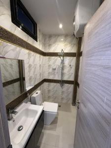 une salle de bain avec un lavabo, des toilettes et une douche dans l'établissement La pépite du confort, à Dakar