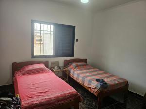 En eller flere senge i et værelse på Joia de Peruíbe