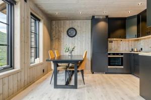 a kitchen with a black table and chairs at Fjellperlen, Hardangervidda in Eidfjord