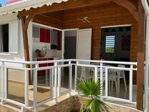eine Veranda eines Hauses mit einem weißen Geländer in der Unterkunft Le Doux Paradise- CORO in Sainte-Rose