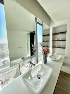 a white bathroom with a sink and a mirror at Departamento Lobby 33 in Guadalajara +22 photos