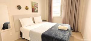 apto 4 quartos 50 metros da praia في باليريو كامبوريو: غرفة نوم عليها سرير وفوط