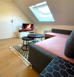 een kamer met een bed en een televisie en een tafel bij La perle des capucins in Reims
