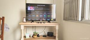 apto 4 quartos 50 metros da praia في باليريو كامبوريو: تلفزيون بشاشة مسطحة جالس على طاولة