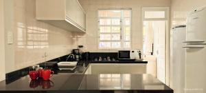 apto 4 quartos 50 metros da praia في باليريو كامبوريو: مطبخ مع منضدة سوداء وبيضاء علوية