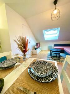 een woonkamer met twee borden op een tafel bij La perle des capucins in Reims