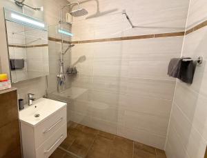 a white bathroom with a shower and a sink at Appartement Oriold in Bad Goisern +4 photos