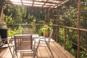 eine Terrasse mit Stühlen, einem Tisch und Stühlen in der Unterkunft San José del Pacífico- Cabañas Camino al Cielo 3 in San Jose del Pacifico + 21 Fotos