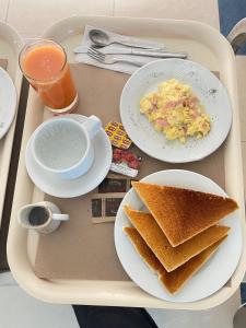 a tray with two plates of food and toast at Hostal Winya in Lima