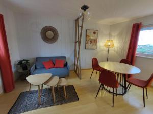 a living room with a couch and a table and chairs at appartement 35m2 in Dompierre-les-Ormes