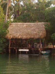 a hut with a table and chairs on the water at Chak in Tonalá