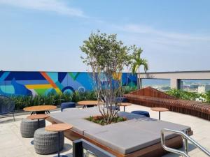 a patio with tables and chairs and a mural at Studio com piscina Centro Rio de Janeiro in Rio de Janeiro