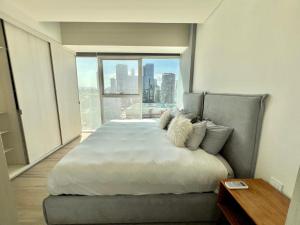 a bedroom with a large bed with a large window at Departamento Lobby 33 in Guadalajara
