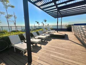 a group of chairs and tables on a deck with the beach at Departamento Lobby 33 in Guadalajara