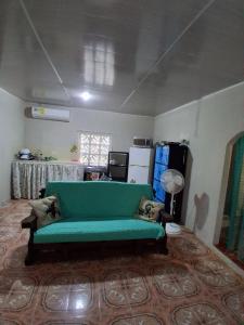 a living room with a green couch in a room at Hospedaje la subidita 1 in Colón