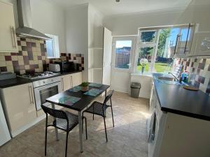 eine Küche mit einem Tisch und Stühlen in einer Küche in der Unterkunft 3 Beds house sleeps 5 Free Parking on drive London Romford PET friendly in Romford