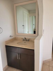 ein Badezimmer mit Waschbecken und Spiegel in der Unterkunft Condo Heated Pool 2 Bed 2 Bath on Sandy Beach at Princesa in Puerto Peñasco
