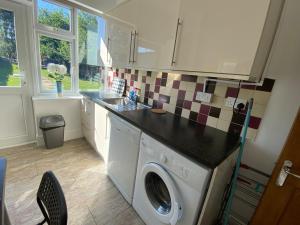 eine Küche mit Waschmaschine und Spüle in der Unterkunft 3 Beds house sleeps 5 Free Parking on drive London Romford PET friendly in Romford