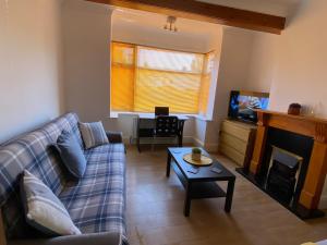 ein Wohnzimmer mit einer Couch, einem Fernseher und einem Tisch in der Unterkunft 3 Beds house sleeps 5 Free Parking on drive London Romford PET friendly in Romford
