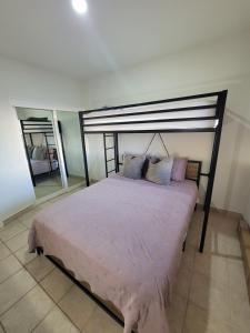 Schlafzimmer mit einem Bett mit rosa Bettwäsche und Spiegeln in der Unterkunft Condo Heated Pool 2 Bed 2 Bath on Sandy Beach at Princesa in Puerto Peñasco + 21 Fotos