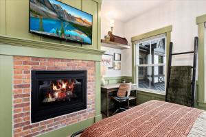 ein Zimmer mit Kamin und einem Fernseher an der Wand in der Unterkunft The Fox Room - Newly Built Downtown Midway Loft in Midway
