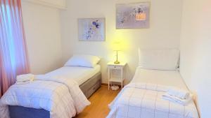 a bedroom with two beds and a lamp on a table at Hostel City Basel 308 in Basel