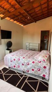 a bedroom with a large bed with a comforter at Encanto de paracuru in Paracuru +24 photos