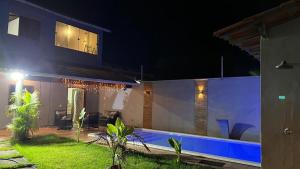 a house with a swimming pool at night at Encanto de paracuru in Paracuru