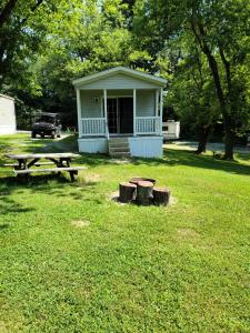 a blue house with a picnic table and a bench at Bayview Campgrounds in Hillsboro