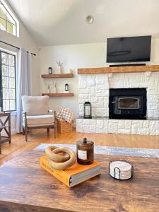 a living room with a stone fireplace with a pretzel on a book at Woodsy Chic Family-Friendly Spacious Getaway in Lake Arrowhead +39 photos