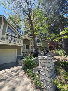 ein Haus mit einer Steinmauer vor einer Einfahrt in der Unterkunft Woodsy Chic Family-Friendly Spacious Getaway in Lake Arrowhead