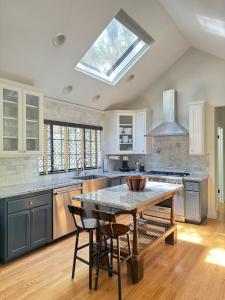 a kitchen with a table with chairs and a skylight at Woodsy Chic Family-Friendly Spacious Getaway in Lake Arrowhead