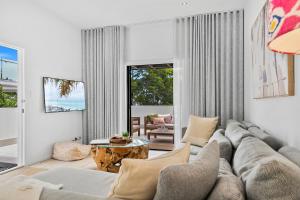 ein Wohnzimmer mit Sofa und Tisch in der Unterkunft Noosa Dreaming in Noosa Heads