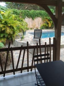 eine Terrasse mit Tisch und Stühlen und einem Pool in der Unterkunft Zabriko delair in Sainte-Anne + 6 Fotos