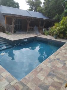 a pool with blue water in front of a house at Zabriko delair in Sainte-Anne