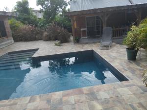 a swimming pool in a yard with a patio at Zabriko delair in Sainte-Anne