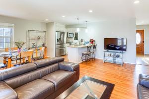sala de estar con sofá marrón y cocina en 5 Mi to Lake Accotink Park Modern Home with Yard, en West Springfield