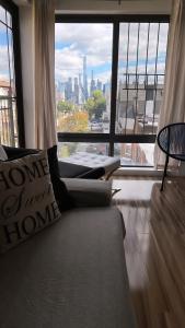 un salon avec un canapé et une grande fenêtre dans l'établissement Furnished 2bed 2bath by Hudson River, à West New York