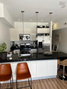 une cuisine avec un comptoir noir et des chaises orange dans l'établissement Furnished 2bed 2bath by Hudson River, à West New York