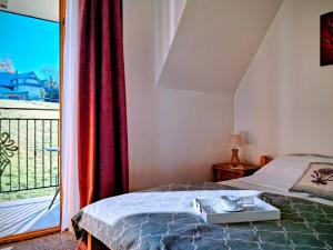 a bedroom with a bed and a large window at Pokoje u Hanki in Murzasichle