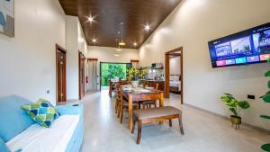 a living room with a blue couch and a dining room at Villa Alma Verde in Fortuna