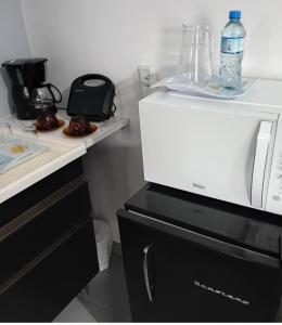 eine weiße Mikrowelle auf einer Theke in der Unterkunft Suites pousada Ilha do Sol in Cananéia